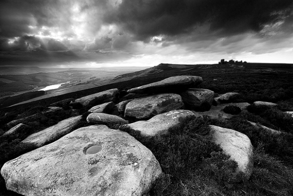 Light punches through overcast skies at Derwent Edge, near the Wheel Stones.